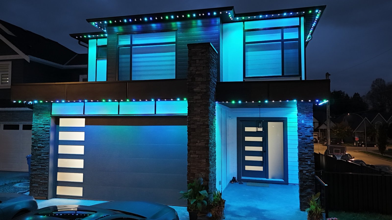 Modern Edmonton home with blue and green permanent exterior lighting